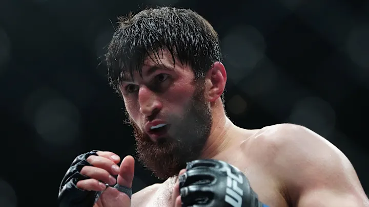 Close-up of a bearded MMA fighter in gloves, sweat on his face, ready to strike in the octagon.