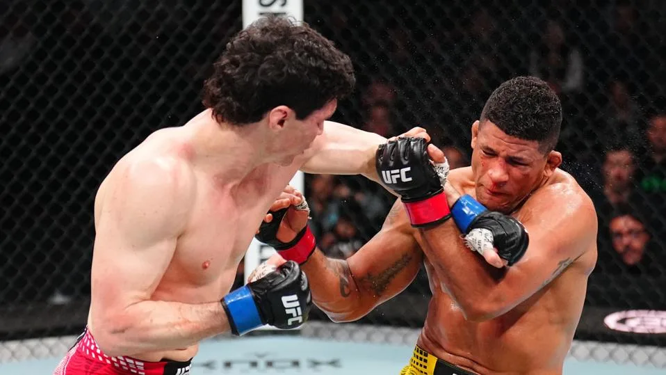 Two UFC fighters in the octagon exchange punches mid-fight, one landing a strike while the other guards.