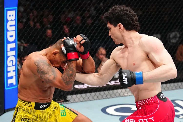 Two UFC fighters in the octagon: a red‑shorts fighter throws a punch while the yellow‑shorts fighter blocks his head with his arms.
