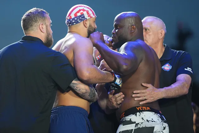 7bd77f9c463f828c3dfee927acf9ae46 - AfroCombat Two muscular fighters face off in a close stare-down, arms linked, as officials step in nearby; one wears a star-spangled bandana.