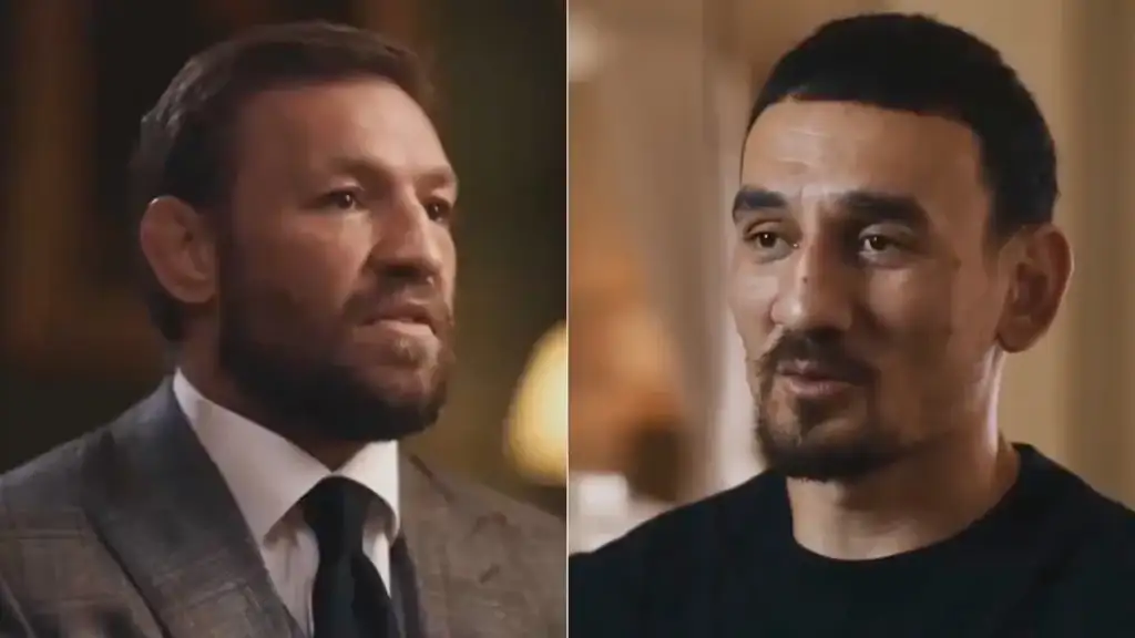 Split-screen of two men in a tense conversation: left man in a gray suit with a beard, right man in a black shirt with facial stubble.