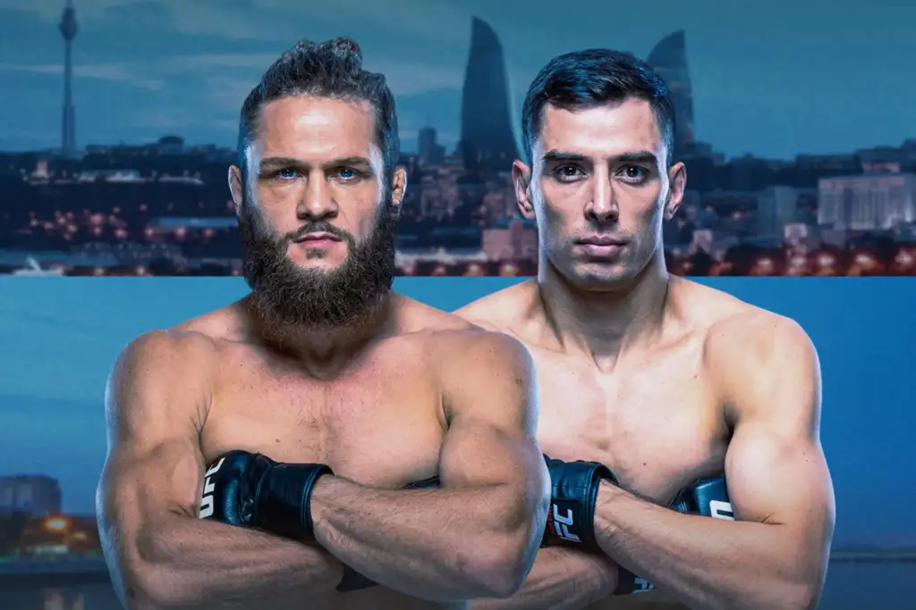 Two muscular men shirtless with UFC gloves cross their arms, posing in front of a city skyline backdrop.