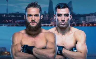 Two muscular men shirtless with UFC gloves cross their arms, posing in front of a city skyline backdrop.