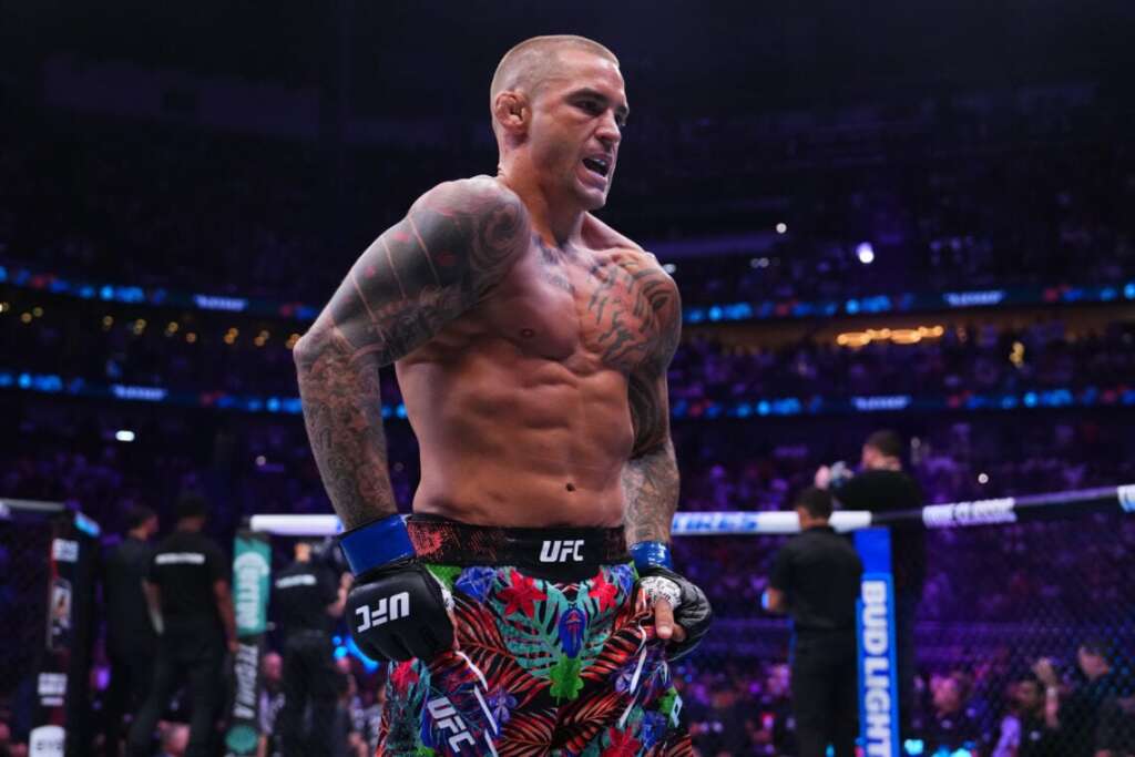 GettyImages-2226077598-1140x760 - AfroCombat UFC fighter with tattoos and colorful floral shorts standing in the octagon, shirtless and looking intense as the crowd watches.