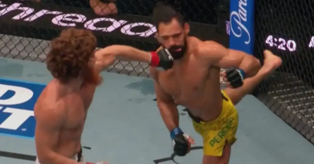 Two shirtless fighters in a cage exchange punches during a mixed martial arts match.