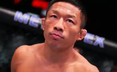 MMA fighter in the octagon, shirtless and sweaty, gazing upward with a thoughtful expression