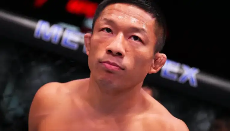 MMA fighter in the octagon, shirtless and sweaty, gazing upward with a thoughtful expression