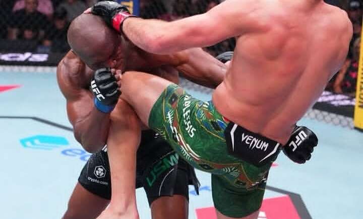 Two UFC fighters collide in the octagon as one delivers a high kick to the other’s head.