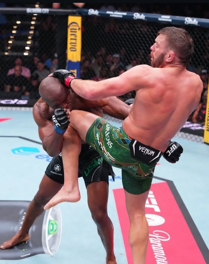 Oplus_131072 - AfroCombat Two UFC fighters collide in the octagon as one delivers a high kick to the other’s head.
