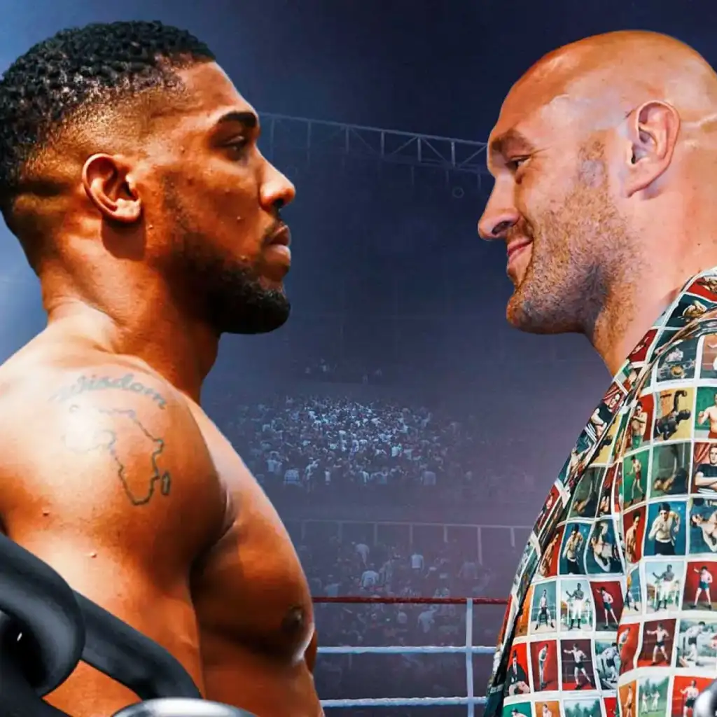 Anthony-Joshua-Tyson-Fury-fight-gets-promising-update - AfroCombat Two muscular boxers face off in a ring, leaning toward each other before a match in a crowded arena.