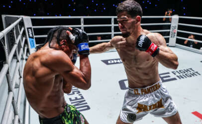 Two shirtless fighters exchange punches inside a boxing ring; one throws a right hand toward the other.