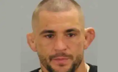 Mugshot of a man with short hair and stubble against a gray backdrop.
