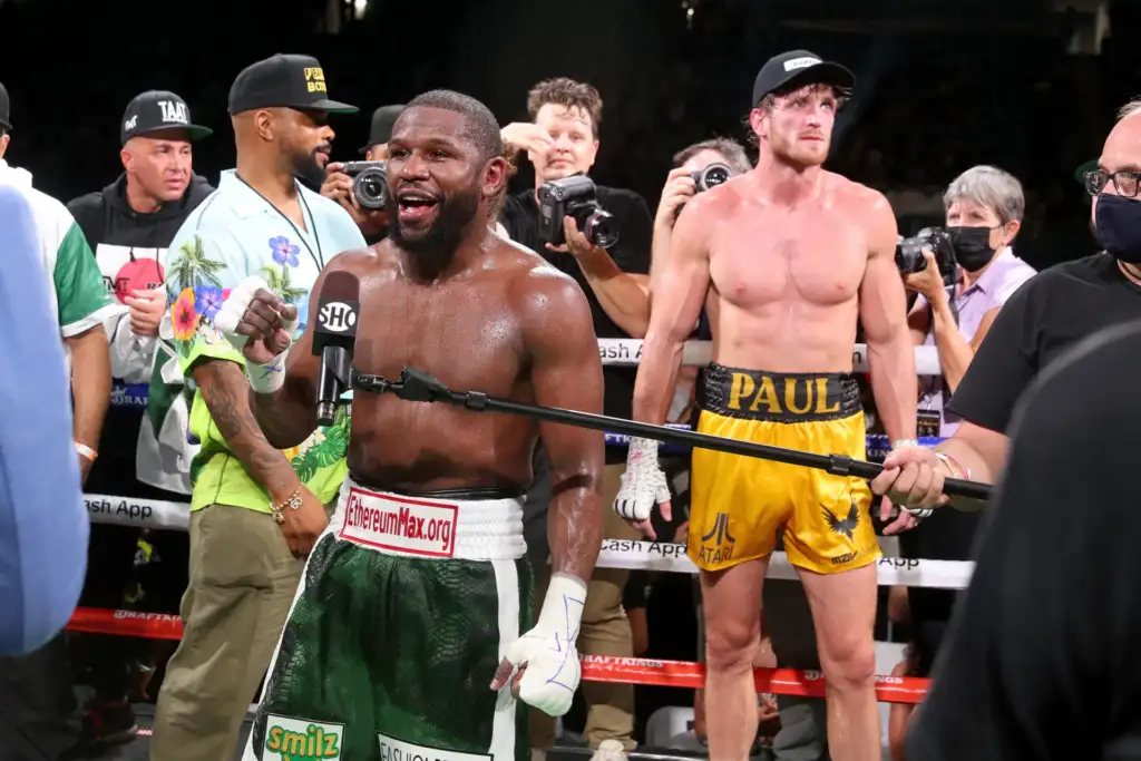 GettyImages-1322315412-scaled - AfroCombat Post-fight scene: a Black boxer in green and white trunks speaks into a Showtime microphone as photographers surround him in the ring.
