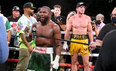 Post-fight scene: a Black boxer in green and white trunks speaks into a Showtime microphone as photographers surround him in the ring.