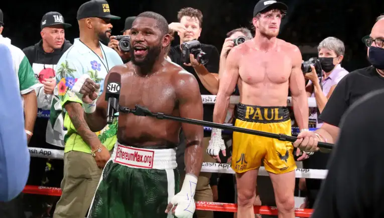 Post-fight scene: a Black boxer in green and white trunks speaks into a Showtime microphone as photographers surround him in the ring.
