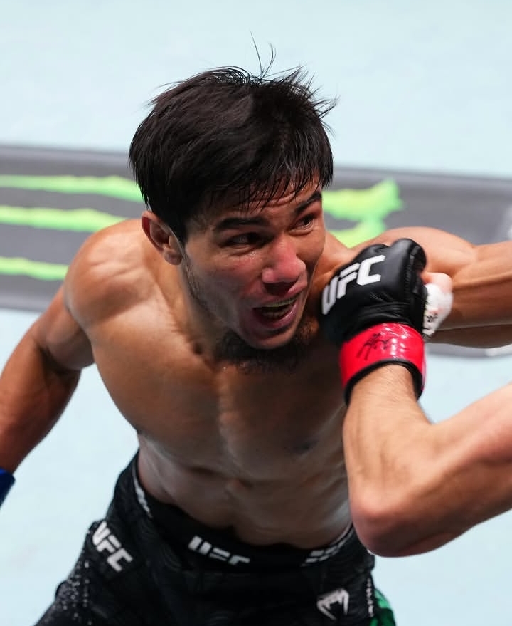 Oplus_131072 - AfroCombat shirtless MMA fighter in black shorts takes a punch during a UFC bout, facial strain and grit visible