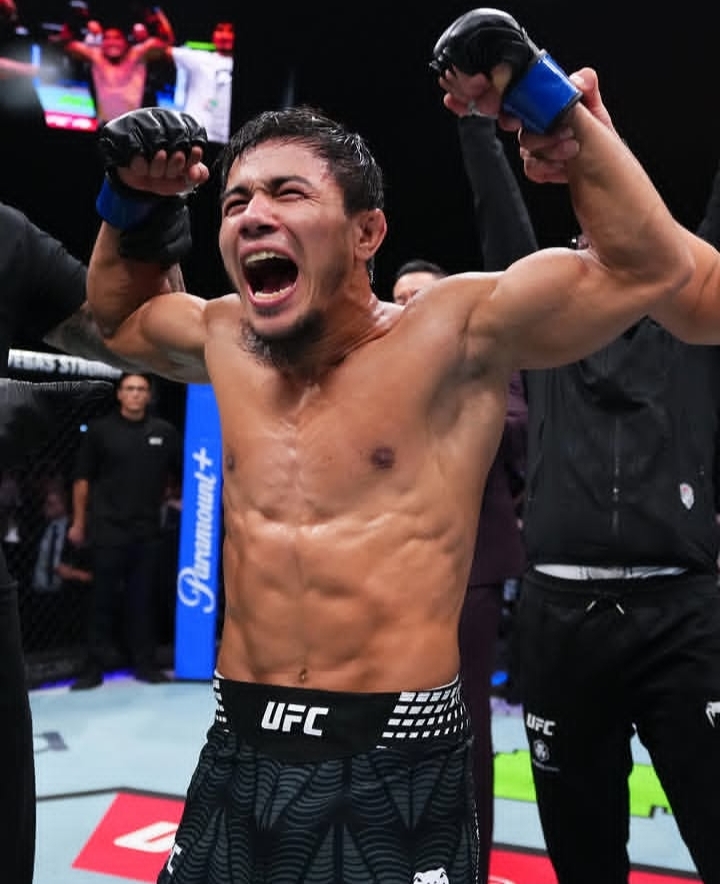 Oplus_131072 - AfroCombat Male mixed martial artist screams with fists raised in victory inside the UFC octagon.