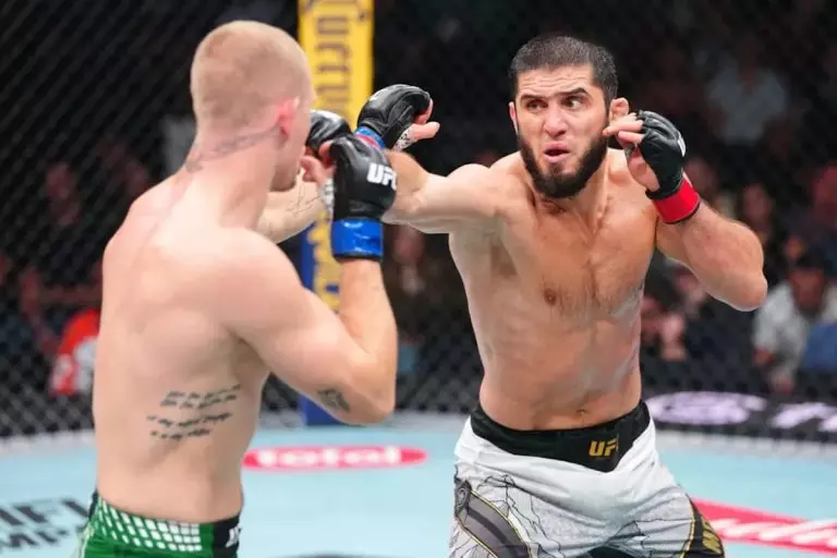 Two UFC fighters clash in the octagon; one throws a punch as the other guards with raised fists.