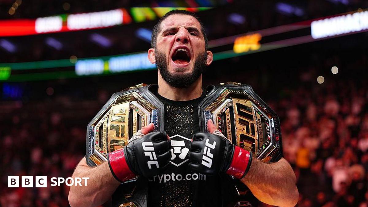 Male UFC fighter with two championship belts, fists raised, shouting in the arena (BBC Sport watermark).