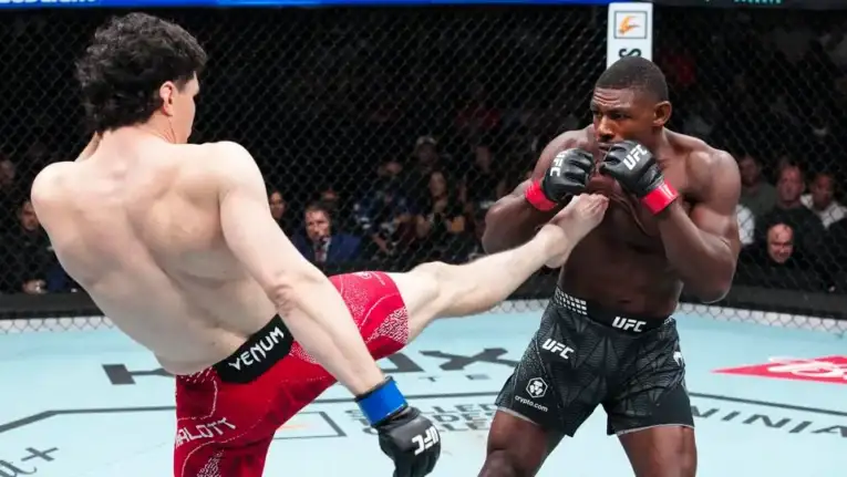 UFC fighters clash in the ring as one lands a high kick to the other’s torso while both guard up inside the octagon.