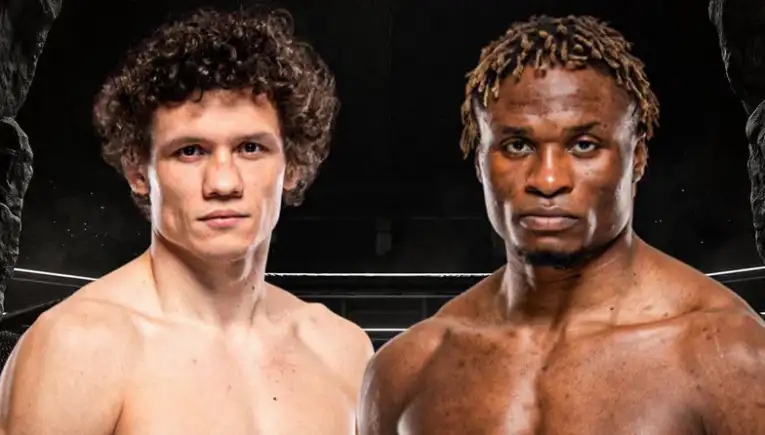 Two shirtless male boxers pose inside a boxing ring, facing the camera with serious expressions.