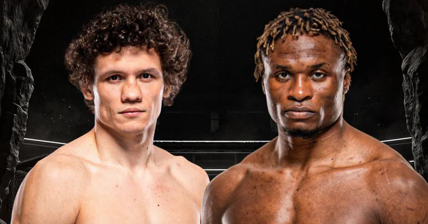 Two shirtless male boxers pose inside a boxing ring, facing the camera with serious expressions.